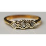 A 9ct gold three stone diamond ring pavé set with small diamond brilliants,