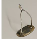 An unusual silver wishbone mounted on a stand, the base engraved M.A.T.