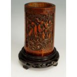 A 19th Century Chinese bamboo brush pot the front carved with three figures in a garden landscape,