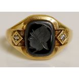 A 9ct gold intaglio and diamond ring the rounded rectangular grey hardstone intaglio carved with a