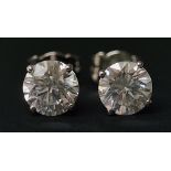A pair of diamond ear studs the circular cut brilliants claw set in 18ct white gold,