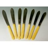Seven ivory handled fish knives with silver blades,