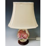 A Moorcroft Pink Magnolia pottery table lamp, slip trail decorated on a cream ground,