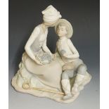 A Nao bisque porcelain figure group decorated in pastel colours of a young boy and girl,