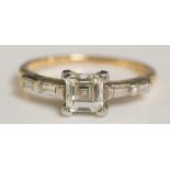 A 14ct gold and platinum diamond set ring the central cushion cut diamond flanked by two pairs of