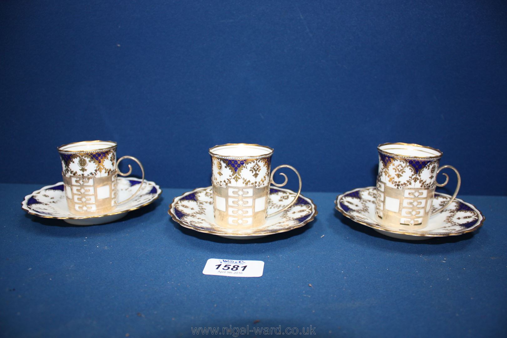 Three Aynsley coffee Cans and saucers, in solid silver holders, 1925, Sheffield.