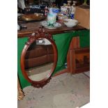 An oval hanging Mirror with wooden decoration, 33 1/2" x 21".