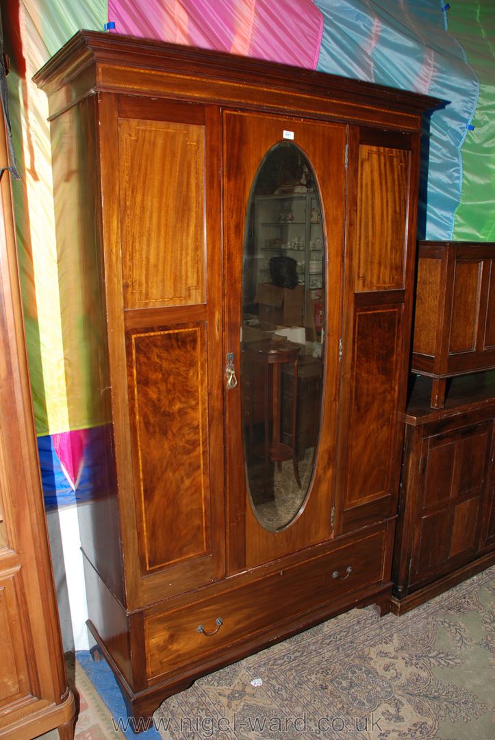 An Edwardian Mahogany single door Wardrobe with moulded cornice over the central single door