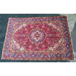 A red ground Persian Tabriz Carpet with traditional medallion design