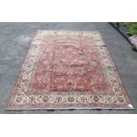 A large hand-made Tabriz Carpet with flower head design on red background, circa 1950, 13' x 10'.