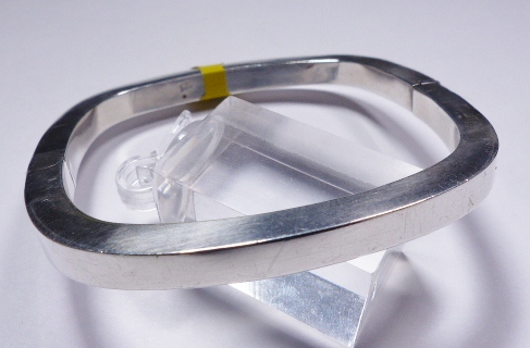 SILVER HINGED BANGLE. Sterling silver cushion shaped hinged bangle