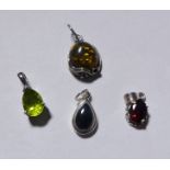 FOUR SILVER PENDANTS. Four silver pendants, peridot, garnet, onyx and amber