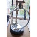 MAGNIFYING GLASS ON WOODEN BASE. White metal magnifying glass on wooden base