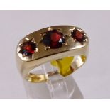 9CT GYPSY RING. 9ct gold gents garnet three stone gypsy set ring, size W