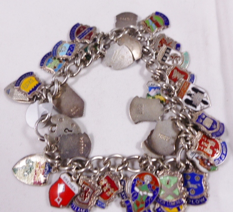 SILVER CHARM BRACELET. Sterling silver charm bracelet full of silver and enamel tabs from towns of