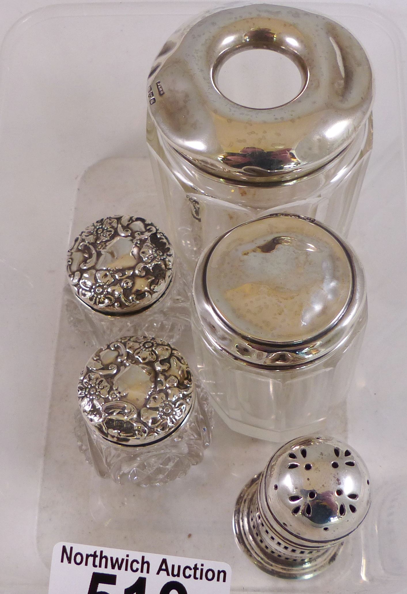 DRESSING TABLE BOTTLES. Four silver topped glass dressing table bottles and a silver pepperette