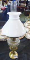 OIL LAMP ON CANDLESTICK. Oil lamp on brass candlestick, H ~ 46cm