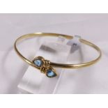 9CT BANGLE SET. 9ct gold bangle set with heart shaped blue topaz