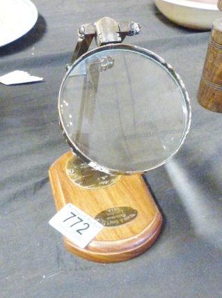 MAGNIFYING GLASS. Brass magnifying glass on wooden base, D ~ 7cm