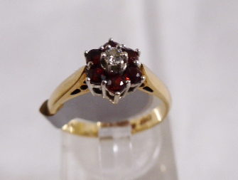 9CT DAISY CLUSTER RING. 9ct gold garnet and daisy cluster ring, size K