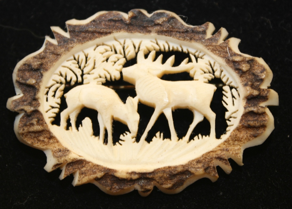 DEER BROOCH - a vintage carved bone brooch depicting a stag and fawn within leafy foliage.