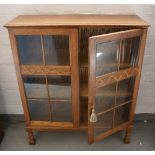 BOOKCASE - a vintage lockable glass doored bookcase with patterned detail on the door.