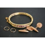 9CT GOLD JEWELLERY - a gold bangle with pink stones (setting for 11 stones, one is missing),