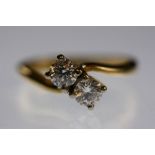 DIAMOND CROSSOVER RING - fine example with two matching brilliant cut diamonds in 4 prong setting
