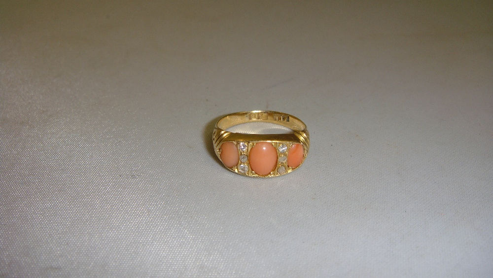 18 ct gold ring set with small diamonds and three graduated cabouchon pink coral 50 m