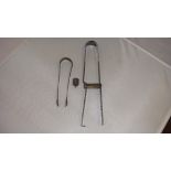 Unmarked early 19th century silver metal sugar tongs with engraved decoration,