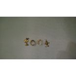 2 unmarked gold metal charms and pair of gold metal earrings set with paste 3 g