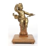 A French gilt bronze figure of Cupid, armed with a bow and seated on an oak plinth, 22cm.