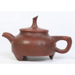 A Chinese Yixing teapot and cover. Carved with bamboo shoots and character inscriptions.