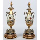 A pair of French porcelain urns with silvered and gilt metal mounts and raised on giltwood plinths.