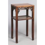 A Chinese hardwood two tier table. With carved openwork frieze and raised on square supports, 79.