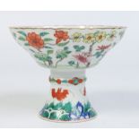 A Chinese famille vert stem bowl with scalloped rim. Painted with flowers and fruit bats, 11cm.