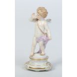 An early 20th century Meissen figure of Cupid stood in a taunting pose and raised on a circular