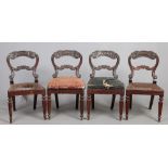 A set of four Victorian carved rosewood balloon back chairs raised on reeded supports.