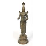 A 19th century large Indian bronze figural deity stood on a circular plinth and modelled with three
