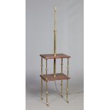 A brass rise and fall standard lamp raised on a brass and rosewood two tier occasional table base,