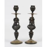 A pair of nineteenth century French patinated and parcel gilt bronze candlesticks.