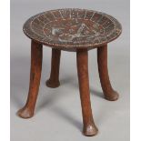 An African carved hardwood dish top stool with piquet inlay inscribed R. W.