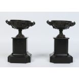 A pair of French Empire slate and patinated bronze mantel garnitures of urn form ornamented with