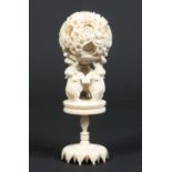 A Cantonese carved ivory ten layer puzzle ball supported by three elephants over a turned pedestal,