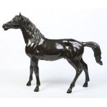 An early 20th century Continental large patinated bronze sculpture of a standing horse, 75cm long.