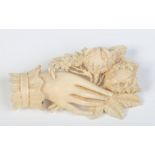 A Dieppe carved ivory brooch formed as a ladies hand grasping flowers, 7cm.