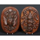 A pair of 19th century Black Forrest oval carved oak wall plaques.