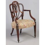 A 19th century carved mahogany shield back carver armchair.