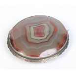 A large silver mounted oval agate brooch, 6.5cm wide. Condition Report.