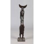 An African patinated bronze statue formed as a tribeswomen holding a stool aloft.